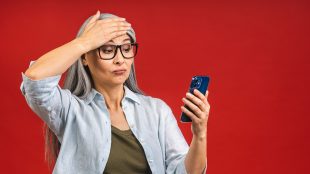 Woman looking in shocked way at her mobile phone