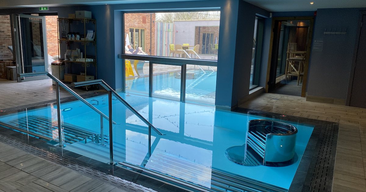 Image shows indoor pool as part of the spa facilities. Pool goes through to the outside spa area