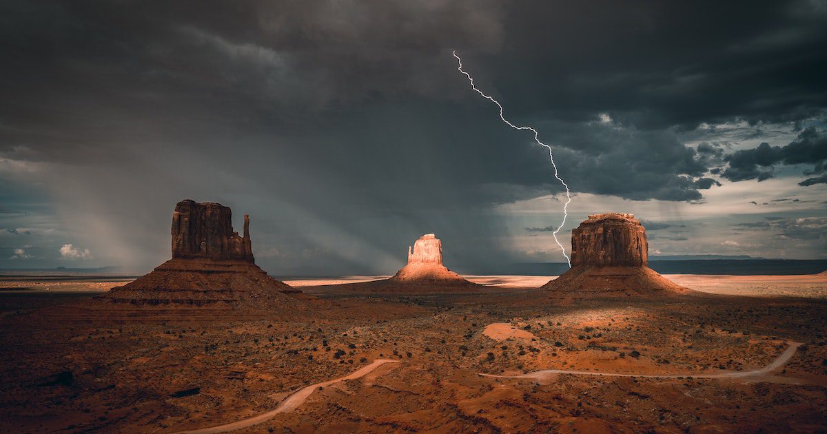 Image shows a vast canyon with two mountains and a streak of lightning