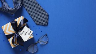 Blue background with a tie, glasses and fathers day gift box
