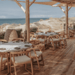 Wood-themed beach bar looking out onto sand dunes and the ocean.