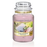 Pink candle in a clear jar, and a label with a picture of a garden.