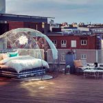 Glass dome over double bed on a rooftop.