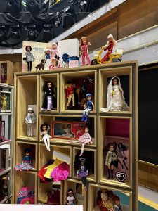 Image shows a stack of shelves with a large collection of Sindy dolls and paraphernalia