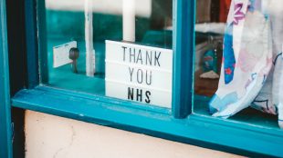 Sign that says 'Thank you NHS' in blue window sill.