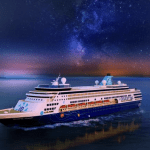 Cruise ship on the water with star lit sky in the background.