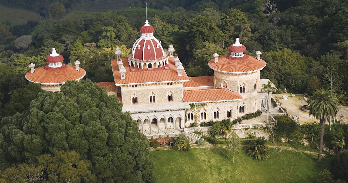 Monserrate palace. Grand cream palace with terracotta roofs set amongst lush greenery. Taking a holiday alone to Cascais