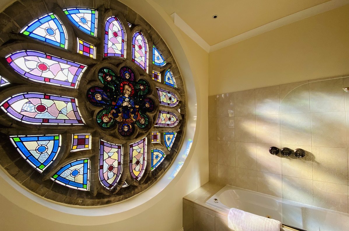 Image shows a bathroom with an enormous circular stained glass window