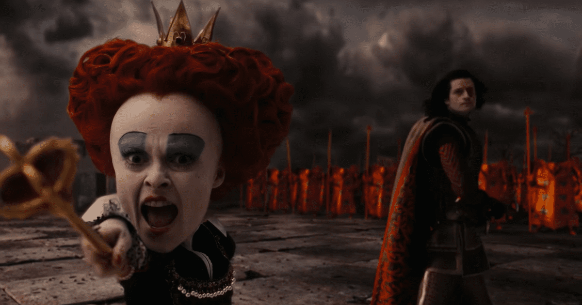 Helena Bonham Carter as the Red Queen from Alice in Wonderland. Red curly hair, bold blue eyeshadow. Stood ahead of a red cladded army. 