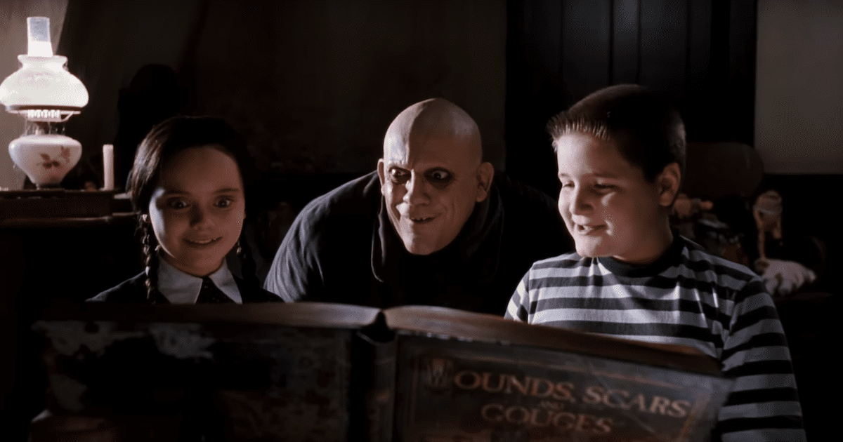 Uncle Fester from the Addams family, with Wednesday on his left and Pubert on the right reading a big book. Halloween films not scary 