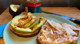 Image showing an open sandwich with chicken and mayo on one slice and avocado and mango chutney on the other.