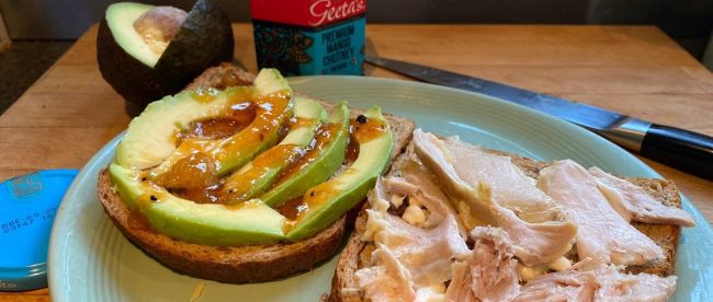 Image showing an open sandwich with chicken and mayo on one slice and avocado and mango chutney on the other.