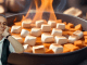 Image of Nick Lezard looking fed up overlayed over an image of a pan with sweet potatoes and marshmallows in. Lezard is leaning against the pan, which is on fire.