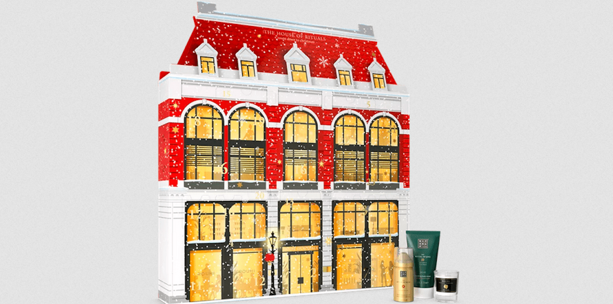 Rituals advent calendar designed to look like a red and white building with lit up windows and snow falling down. 