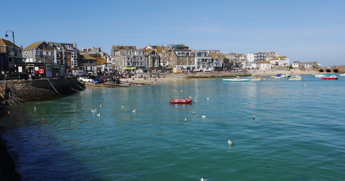 Harbour town in Cornwall, beautiful blue waters and boats. Best tours England for over 50s