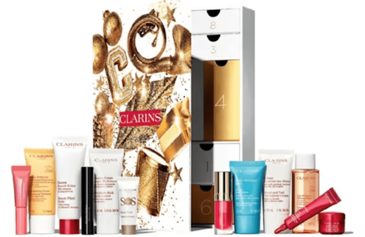 Clarins advent calendar. White calendar that opens with little draws. Clarins products surround the calendar. 