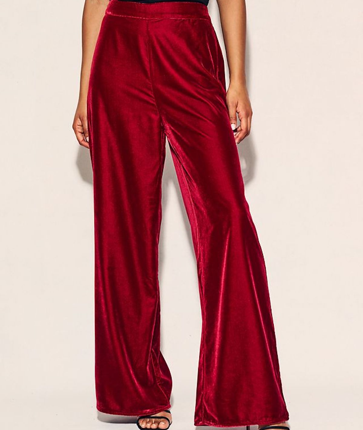 Red velvet wide-leg trousers modelled against a peach backdrop. Women's party wear ideas on Silver