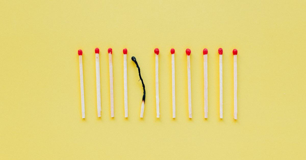 An image of a line of matches, with one burned out, on a simple yellow background.