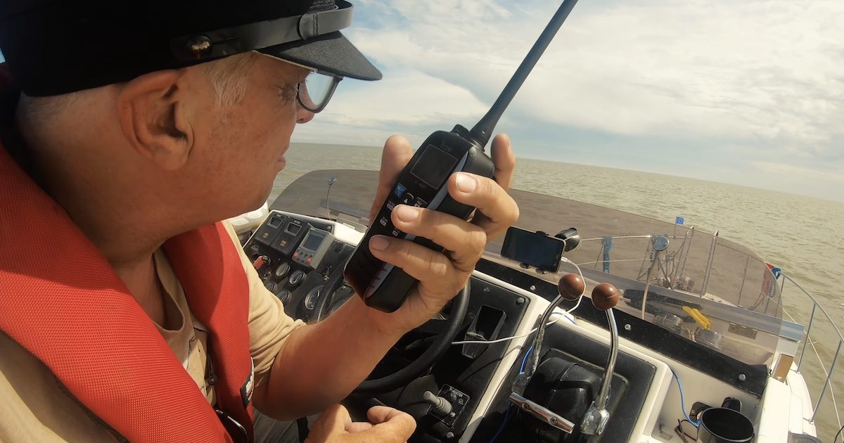 Stephen Payne sat at the cockpit of the boat, holding a walkie talkie