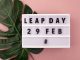 White block calendar present date 29 and month February and plant on pink. Leap day